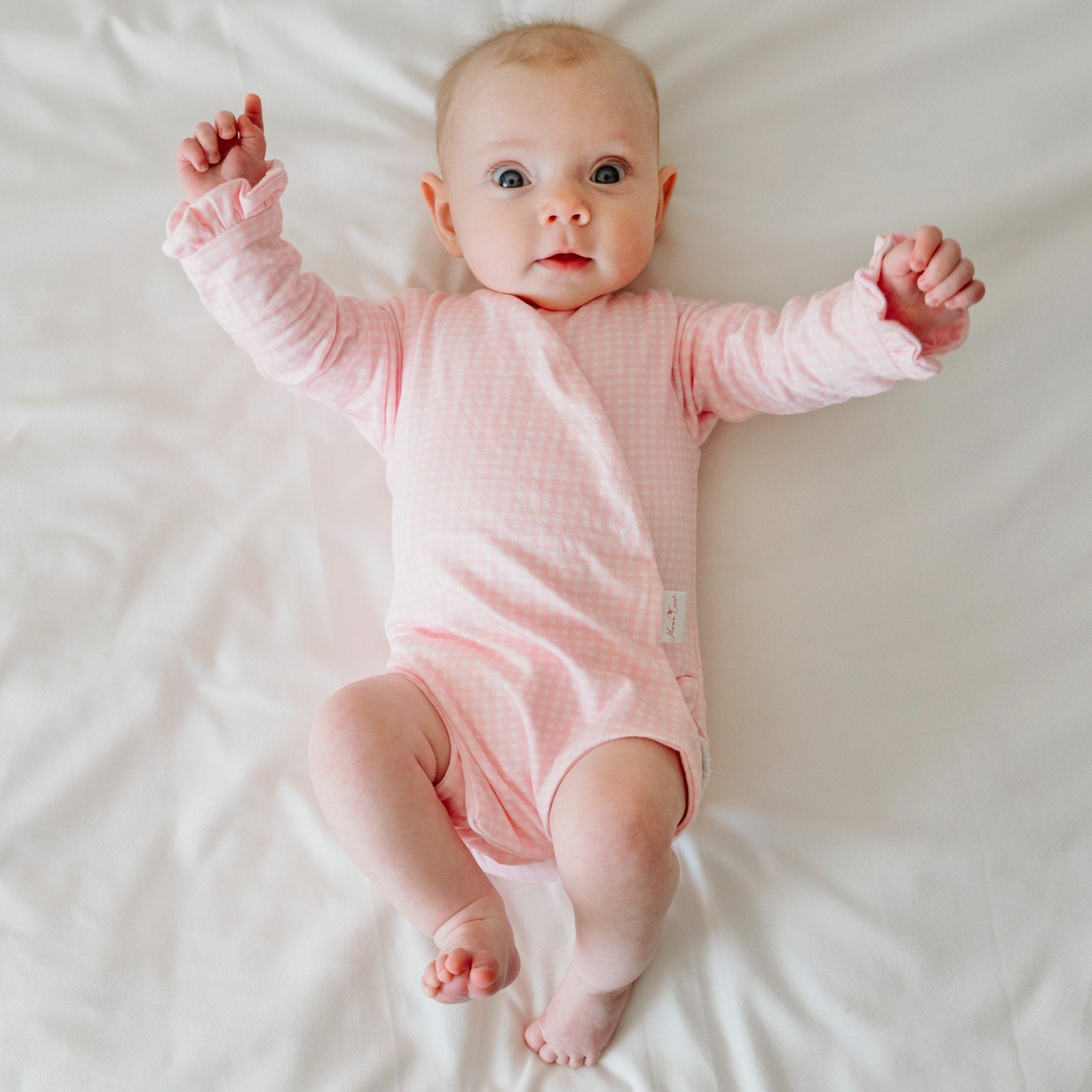 Baby pink gingham design ruffle cuff long sleeve onesie.