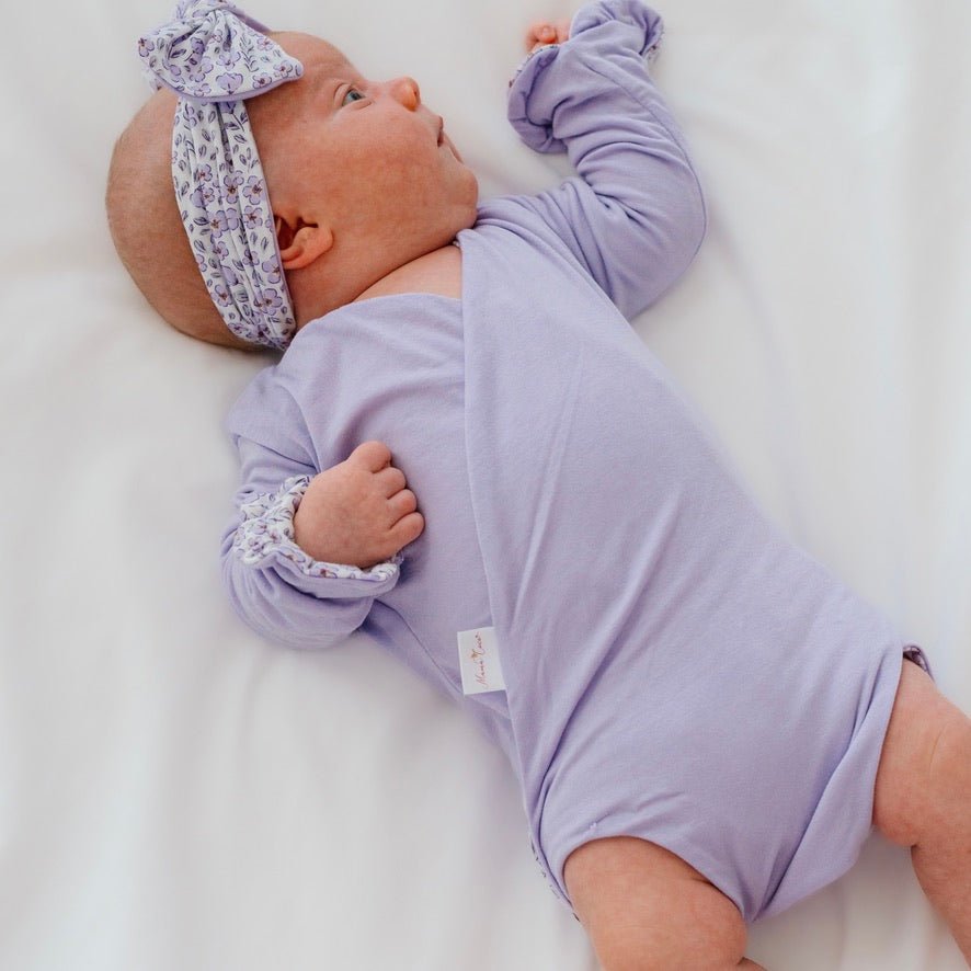 Reversible long sleeved winged bodysuit for babies in silky modal fabric with ruffle cuffs.