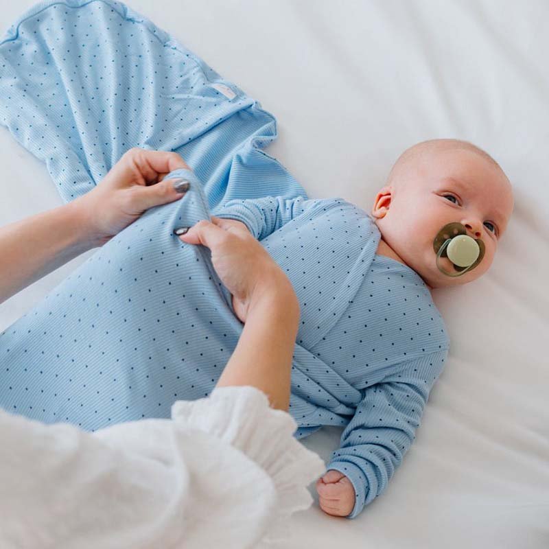 Soft Dotted Blues design on a Cocoon swaddle baby blanket in Silky Modal fabric styles.