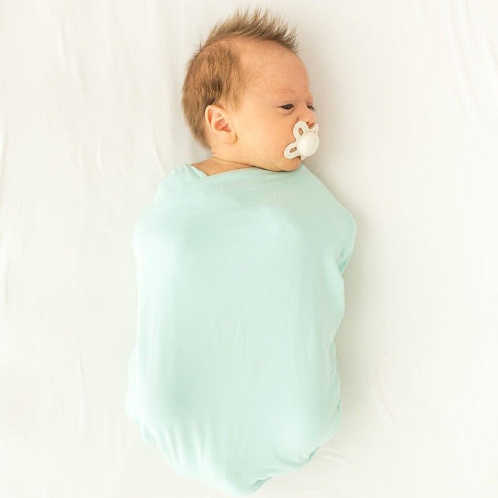Newborn baby cocoon swaddle featuring Honeydew Palms Silky Modal fabric.