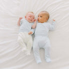 Two babies wearing our silky modal footie pants in Baby Blue Gingham design.