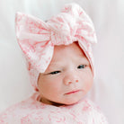 Sweet bow headwrap for babies made from soft bamboo and organic cotton fabric in a whimsical garden print.
