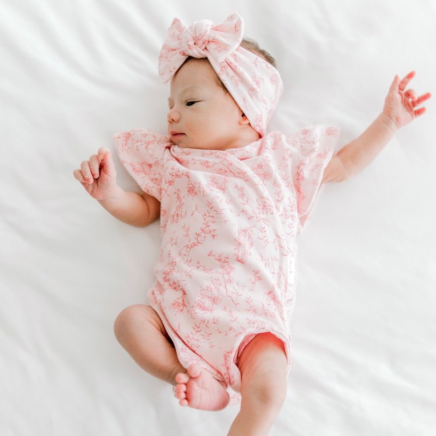 Whimsical garden design flutter sleeve baby onesie in bamboo cotton fabric.