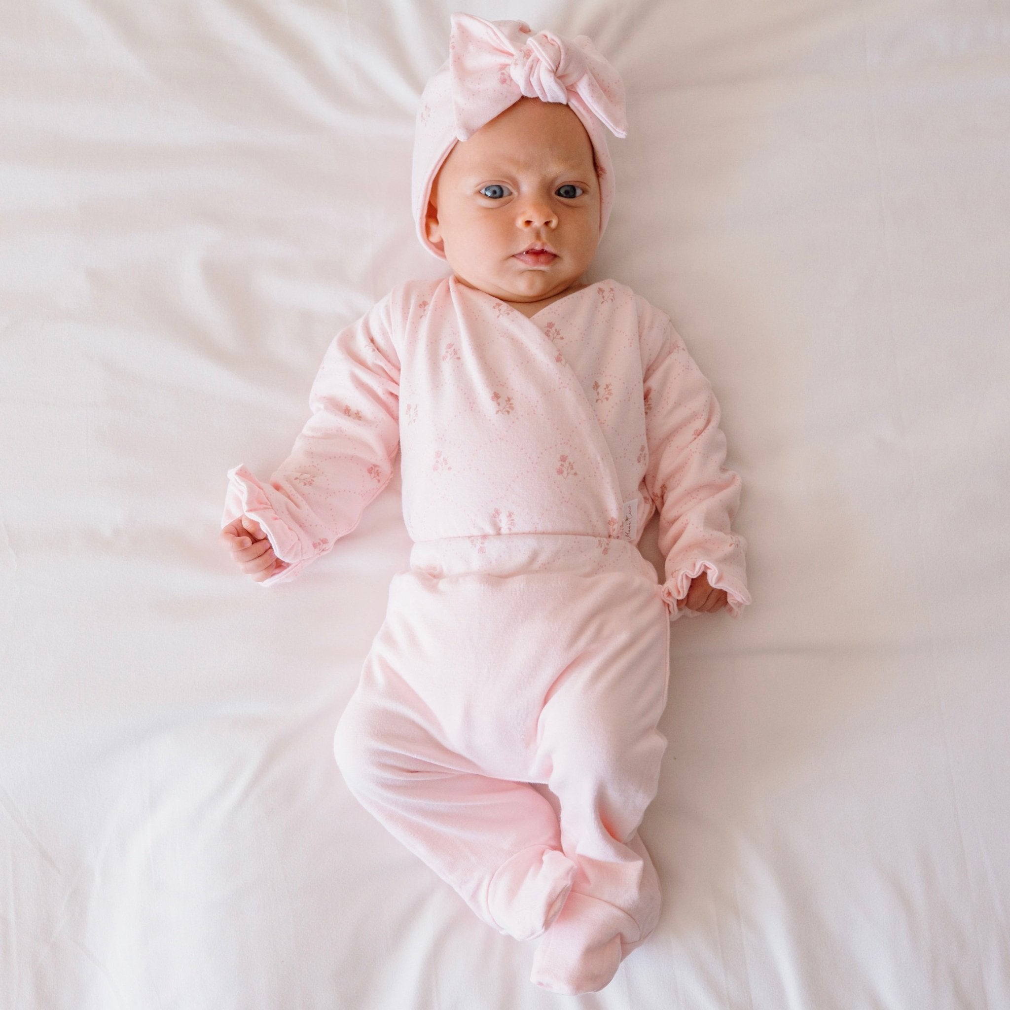 Reversible ruffle cuff long sleeve baby onesie made from bamboo cotton.