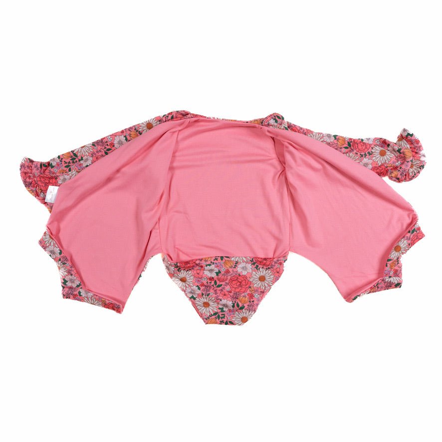 Winged long sleeve infant bodysuit crafted from cozy Flower Power design reversible brushed fabric with ruffle cuffs.