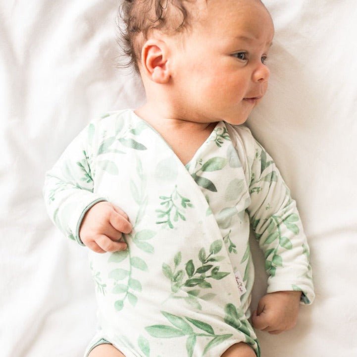 Reversible long-sleeve winged bodysuit in saged eucalyptus design.