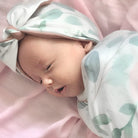Cozy ruched beanie with bow for babies featuring the gentle Blushing Eucalyptus print.